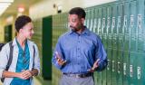 Teacher and high school student walking in hallway